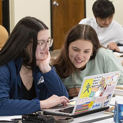 Sociology students smile while working on a research project.