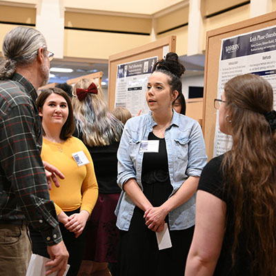 Anthropology students discuss their work during a poster presentation.