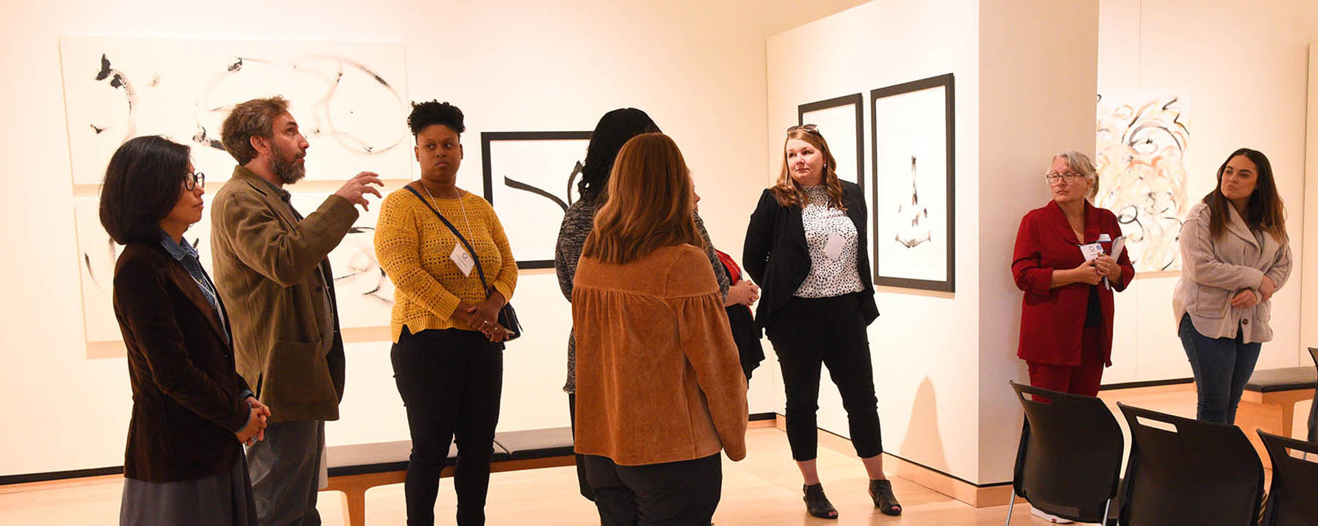 people standing and talking in art gallery