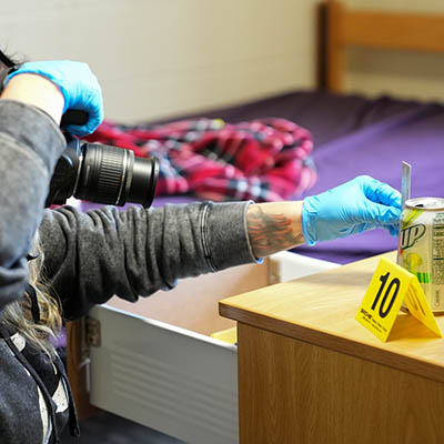 Students exam bullet holes with an instrument