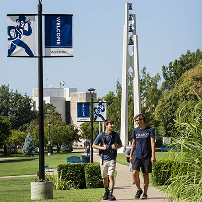 Washburn students chat while walking across campus.