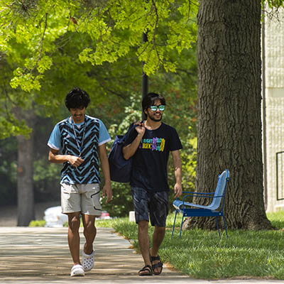 Students carry a bag of laundry to their residence hall.