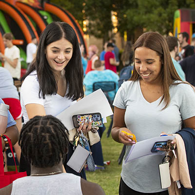 Two students smile while checking out community offerings.