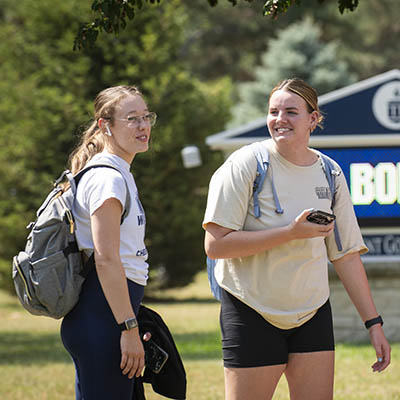 Two students chat outside.