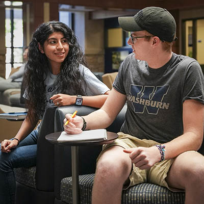 Three students smile while hanging out on campus.