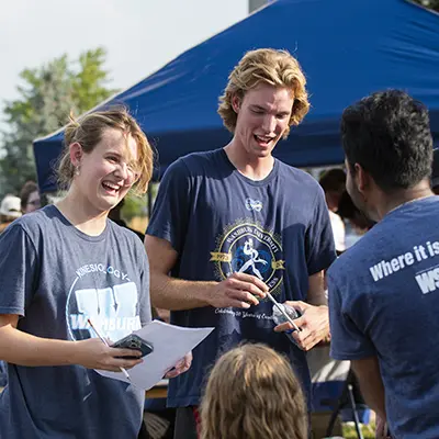 Students smile and chat at an event on campus.