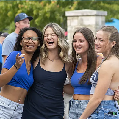 A group of students laugh while posing for a photo together.