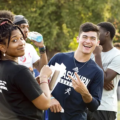 A group of students smiles at an event during welcome week.