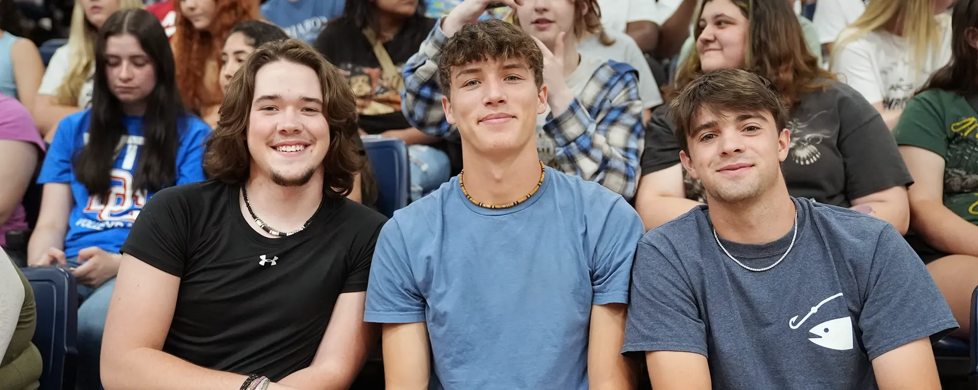 Three freshmen students smile at a Welcome Week event.