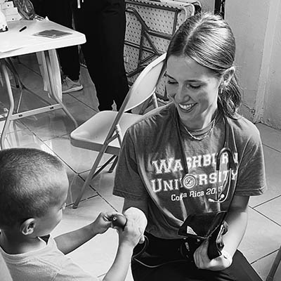 Elsa shows a child a stethoscope 