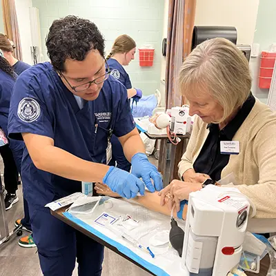 A professor and student work together on a patient simulation.