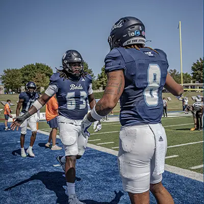 Football players slap hands.