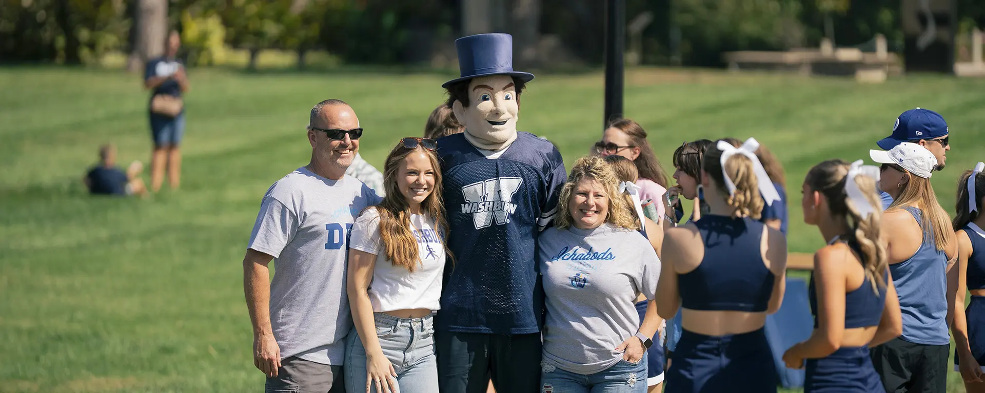 A family wearing Washburn clothing poses for a photo on Family Day.